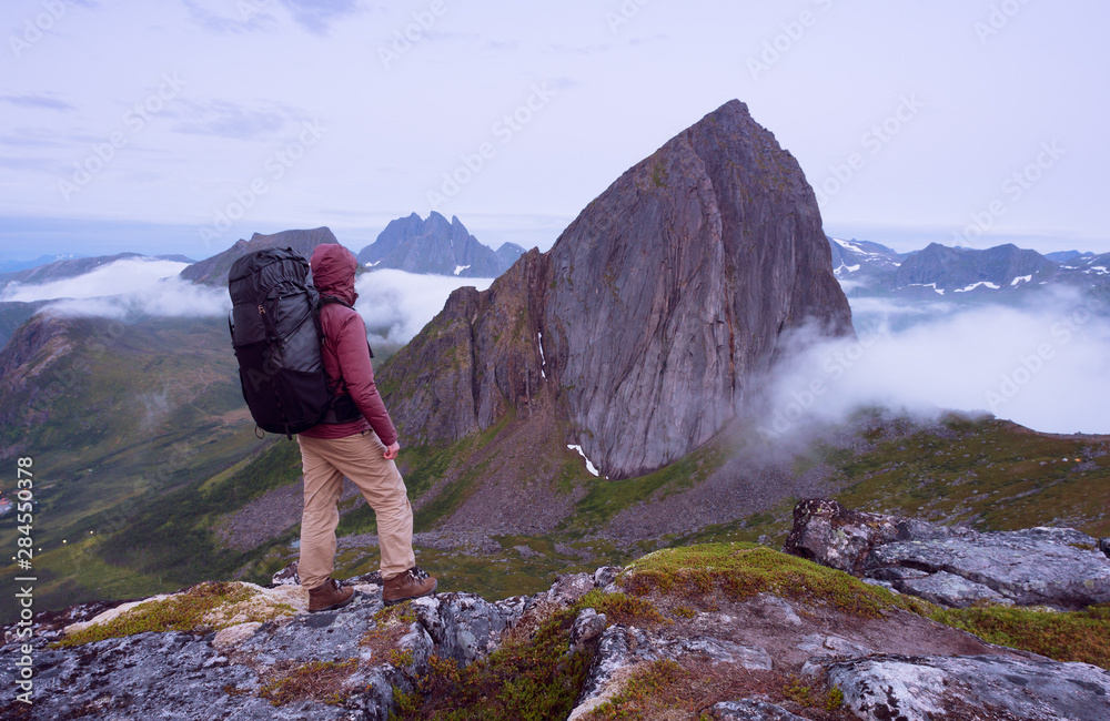 Tourist stands on background of Segla Mountain. Senja, Norway Tourist stands on background of Segla Mountain. Senja, Norway