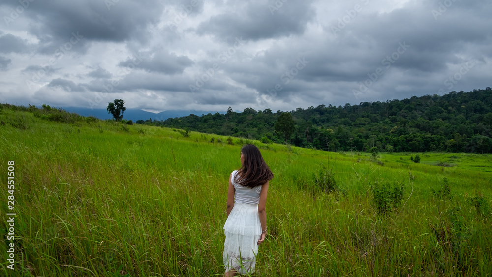 Girl with white dress in a green field,enjoying in the sunny summer day