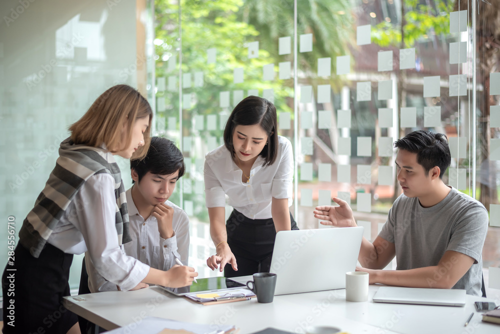 Group of young business people brainstorming at a meeting starting a new business. Group of young business people brainstorming at a meeting starting a new business.
