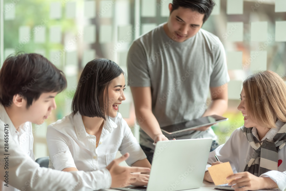 Group of young business people brainstorming at a meeting starting a new business. Group of young business people brainstorming at a meeting starting a new business.