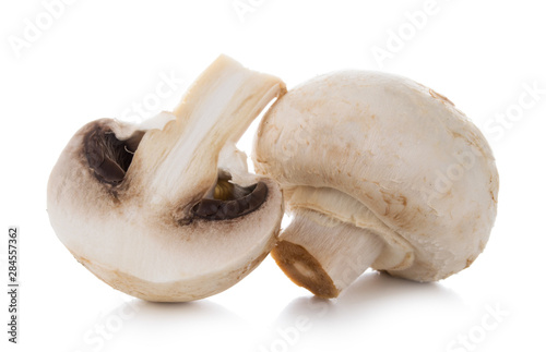 Two mashrooms whole and sliced champignons isolated on white background