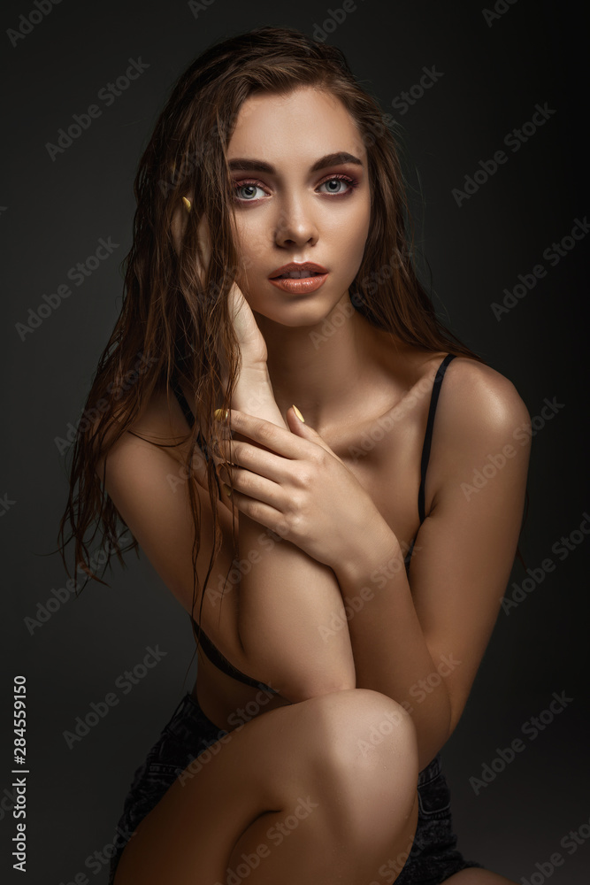 portrait of gorgeous sexy woman with perfect skin and long wet hair on dark background. girl looking at camera portrait of gorgeous sexy woman with perfect skin and long wet hair on dark background. girl looking at camera