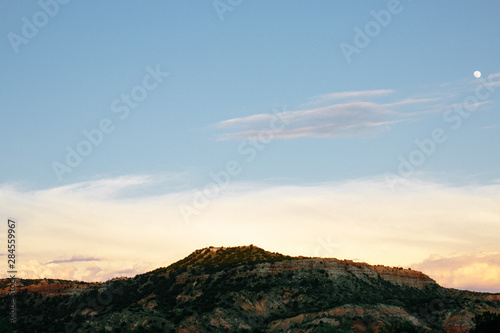 palo duro canyon at sunset, clouds and moon in sky, dessert horizon 