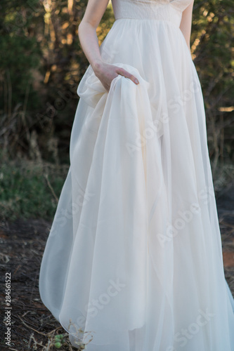 Bride holding wedding dress train