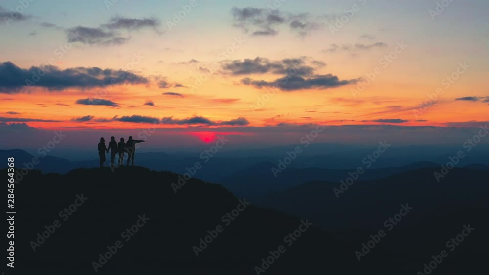 The four friends standing on a mountain with the beautiful sunrise The four friends standing on a mountain with the beautiful sunrise