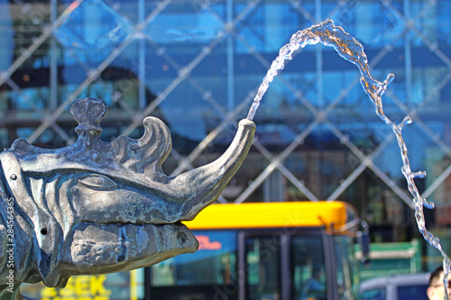 Copenhagen, Denmark - Dragon head spouting water with blurred city background. Detail of the Dragon fountain in Radhuspladsen , bronze group built in 1904