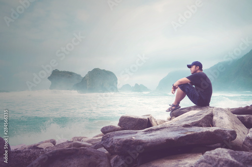 Asian young man enjoys a Papuma beach view photo