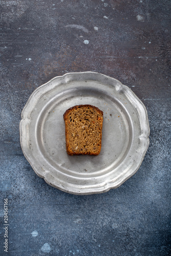 Piece of bread on plate in grunge setting. Poor and lacking nutrition