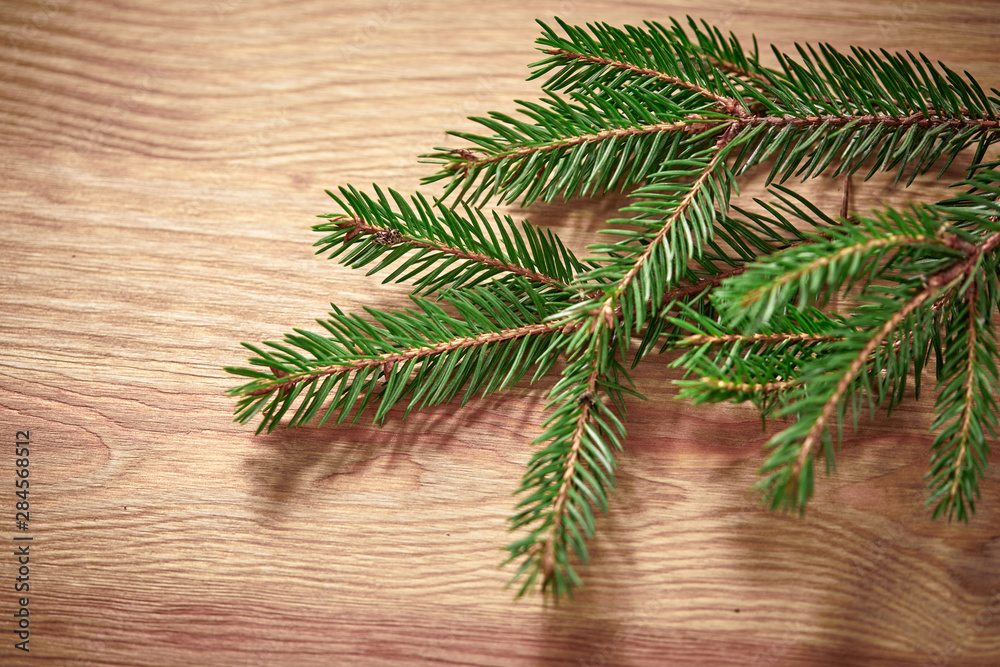 Christmas card - Christmas tree branches on the wooden background Christmas card - Christmas tree branches on the wooden background