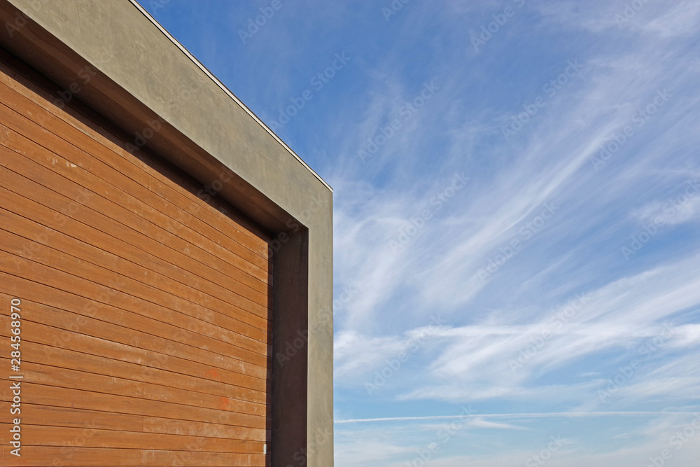 View of the top corner of a modern city building with blue sky and vivid clouds View of the top corner of a modern city building with blue sky and vivid clouds