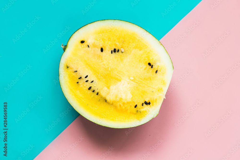 half of ripe yellow watermelon on pink-blue background half of ripe yellow watermelon on pink-blue background