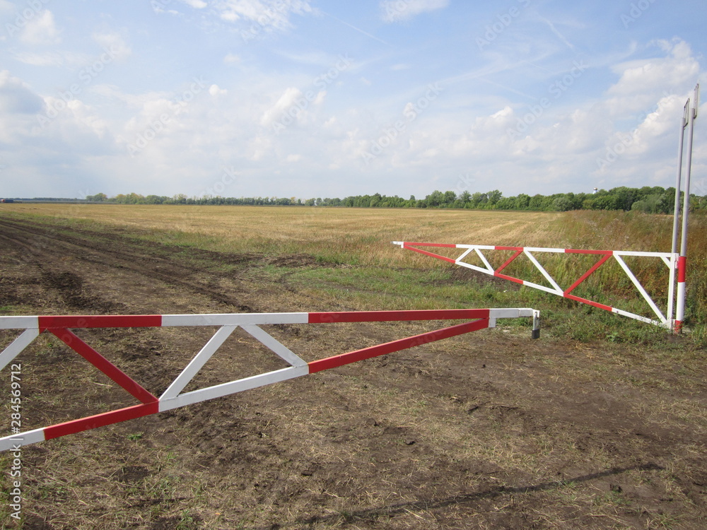 The red-white barrier at the checkpoint of a private orchard The red-white barrier at the checkpoint of a private orchard