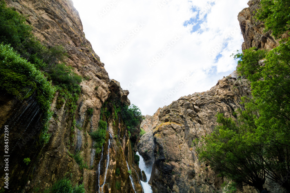 waterfall in the mountains with clouds