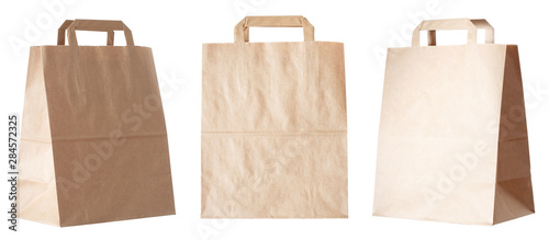 Set of new empty blank paper bag with handles without inscriptions and logos. Made from brown kraft paper. Isolated on white background.