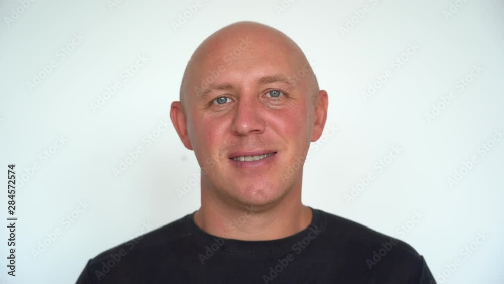 Closeup shoot of middle-aged caucasian bald man looking straight at camera. People and lifestyle concept. Portrait of middle aged man indoors Closeup shoot of middle-aged caucasian bald man looking straight at camera. People and lifestyle concept. Portrait of middle aged man indoors