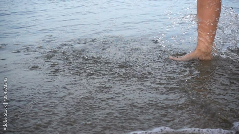 Slow motion of bare feet on the water at the seashore. Slow motion of bare feet on the water at the seashore.