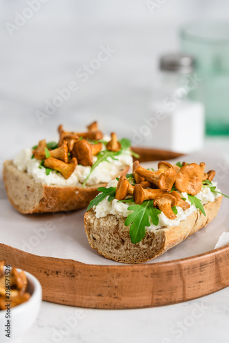 Sandwiches with mushrooms chanterelles, arugula and cream cheese. Bruschetta with mushrooms. Close-up. Selective focus