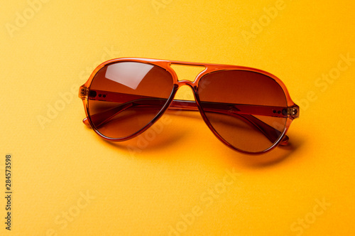 Stylish plastic dark sunglasses on colorful background. Eye care and diseases concept, eye protection.