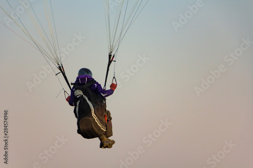 Paraglider prepares to fly in the open air against the sunset sky. Parachute in the backpack outdoors