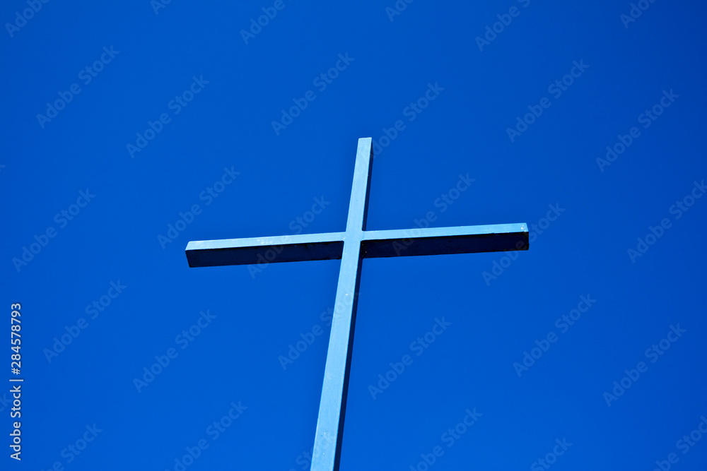 A blue cross of a church towards the blue sky in Bavaria, Germany