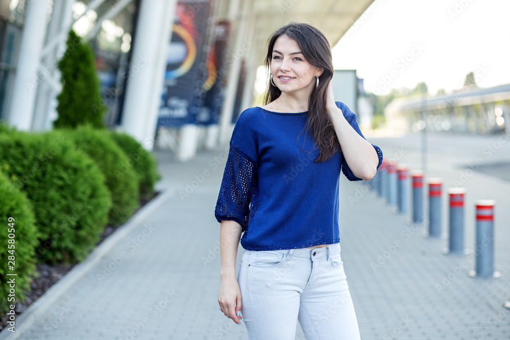 Beautiful girl in a blue t-shirt. Woman on the street. Concept for lifestyle, fashion.