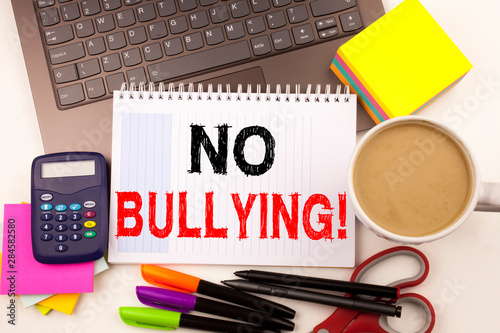 No Bullying text in the office with surroundings such as laptop, marker, pen, stationery, coffee. Business concept for Bullies Prevention Against School Work or Cyber Internet Harassment background