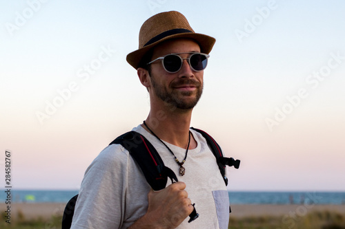Modelo paseando delante de la playa con sombrero y gafas © Cvilaclara
