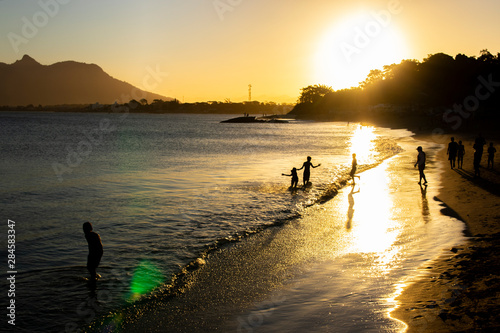 silhouette of people at sunset, at boca da barra beach, in rio das ostras, rio de janeiro, brazil
