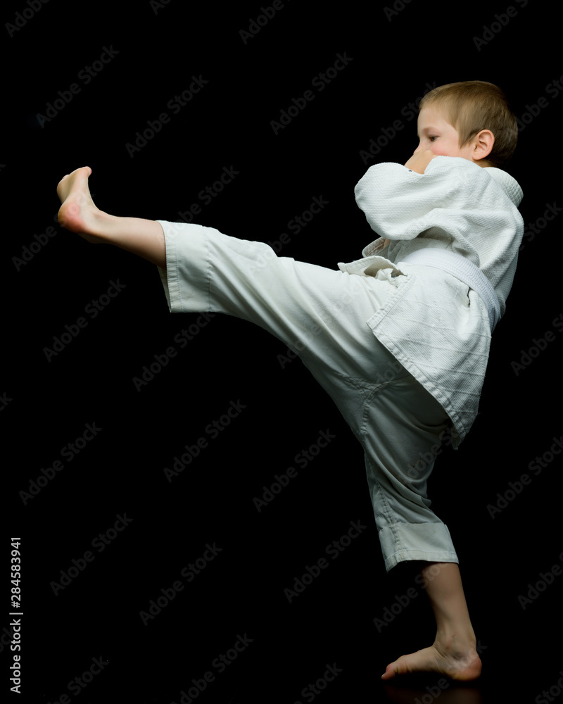 A little boy in a white kimono fulfills blows A little boy in a white kimono fulfills blows
