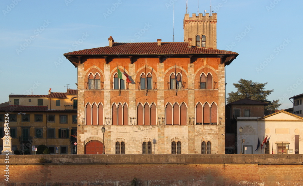 Gothic facade at Palazzo Medici in Pisa, Italy, in the evening sun