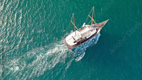 Aerial drone view of small vintage wooden schooner sailing in Balearic islands © aerial-drone