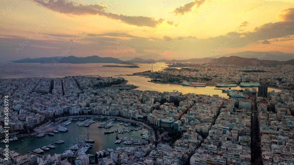 Obraz premium Aerial drone photo of iconic round port of and Marina of Zea or Pasa Limani at sunset with beautiful golden colours and cloudy clear sky, Piraeus, Attica, Greece