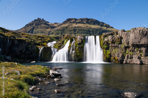 Long exposure photo of Kirkjufellsfoss waterfall at sunny day