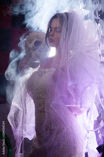 Portrait of the beautiful bride against a light indoors in the smoke photo