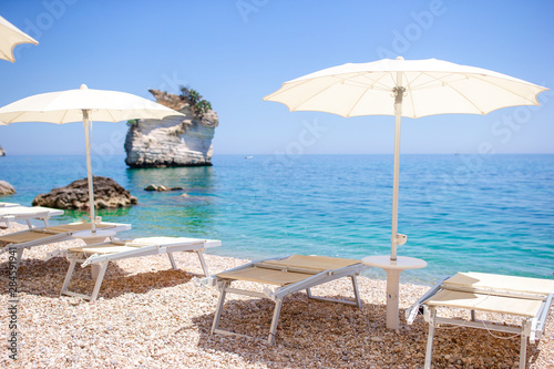 White umbrella and sunbeds at tropical beach