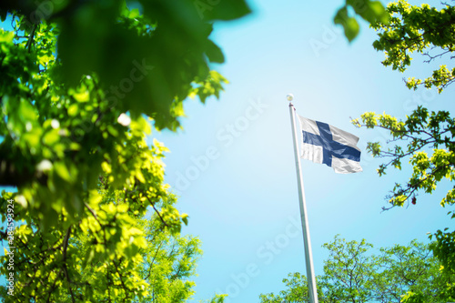 Finland flag, Finnish flag waving in the wind between trees
