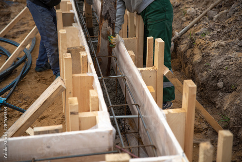 Workers pour concrete into the foundation