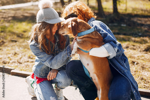 Beautiful girls in a park. Stylish women in a jeans jacket. Ladies with a dog. Mother with a daughter
