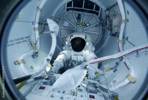 Fototapeta Naklejka Na Ścianę i Meble -  Astronaut at the control panel in a space shuttle.  Elements of this image were furnished by NASA