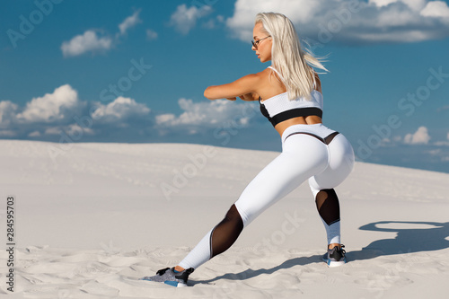 Fitness woman doing lunges exercises for leg muscle workout training. Active girl doing one leg step lunge exercise, outdoor © nikolas_jkd