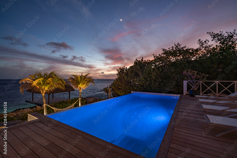 Sunset over the sea from a house and swimming pool