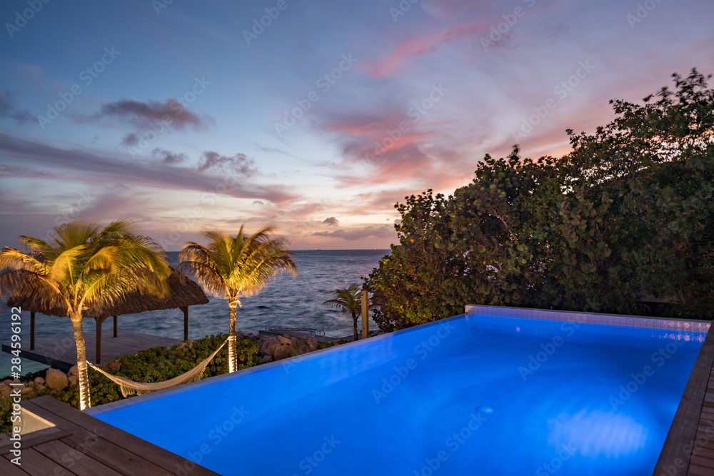 Sunset over the sea from a house and swimming pool