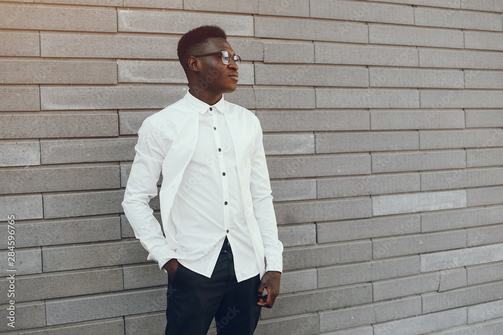 Handsome black man in a city. Businessman in a white shirt Handsome black man in a city. Businessman in a white shirt