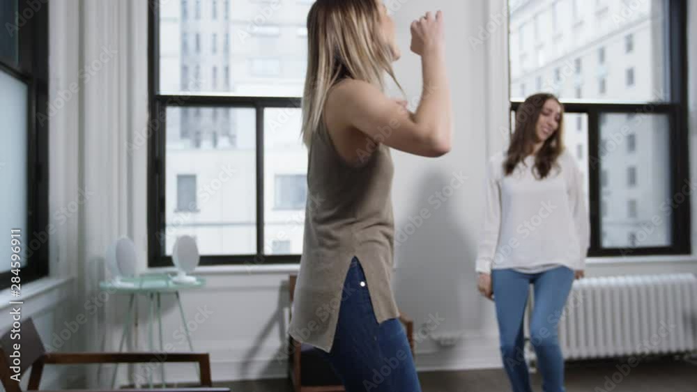 Two young girl friends dancing in a hip urban flat Two young girl friends dancing in a hip urban flat