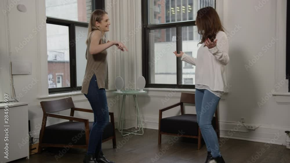 Two young girl friends dancing in a hip urban flat Two young girl friends dancing in a hip urban flat