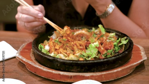 Wallpaper Mural Person eating spicy grilled octopus dish at Korean restaurant Torontodigital.ca