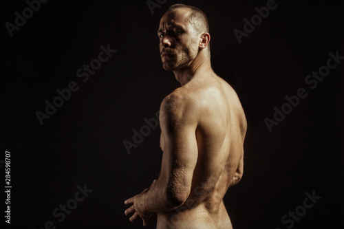 Handsome sport sexy stripped guy portrait for cosmetics and fitness drops on isolated black background