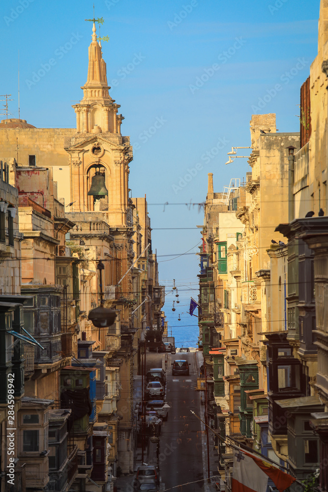 Old Narrow Street With Traditional Closed Wooden Balconies In Valletta city, Malta