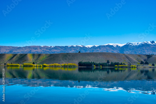 Beautiful snow capped Southern Alps reflections on Lake Dunstan in New Zealand photo