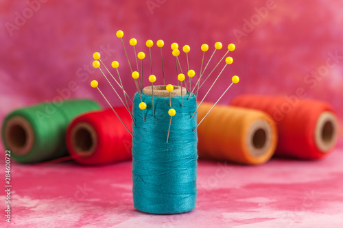 green and turquoise threads and yellow pins 